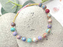 Load image into Gallery viewer, lilac and blue sea sediment stones on a pink cord with tiny gold coloured glass beads to finish it off