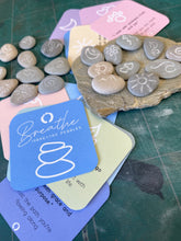 Load image into Gallery viewer, Hand engraved natural beach pebbles for you to use in your 10 breaths practice. thise pebbles are engraved with grounding affirmation symbols. They come with a set of 10 affirmation cards for you to use with your stones.