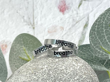 Load image into Gallery viewer, Hand stamped rings with the word breathe stamped and then enamelled in black. Hypoallergenic and tarnish resistant. Unisex, can be worn by all as its adjustable, can be worn by most.
Handstamped so NOT PERFECT!