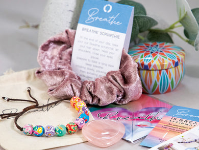 The ultimate chill and relax gift, a 10 Breaths Bracelet, soy wax candle, palm thumb stone, a velveteen heart scruchie, affirmation card and origami book mark heart.