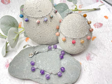 Load image into Gallery viewer, Jewelry set with bracelets on stones and eucalyptus leaves, showing Amethyst, Rhodonite and Jasper stones.

